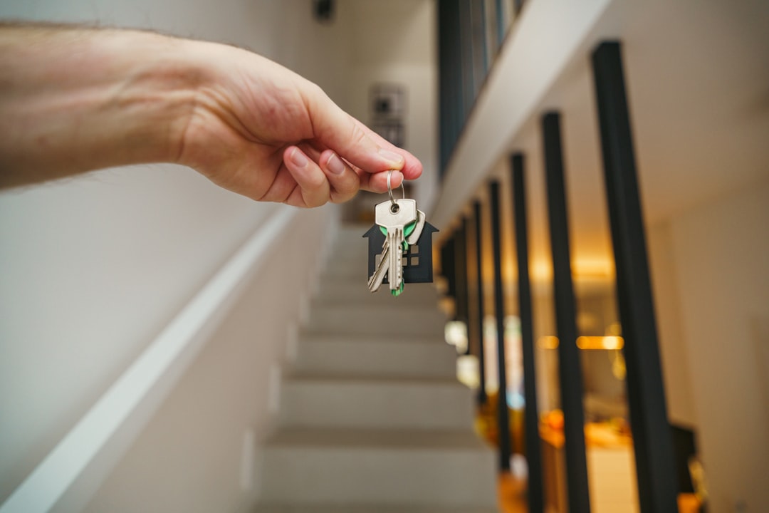 Apartment keys held in front of a modern home interior