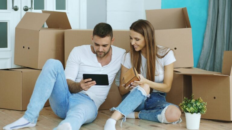 Couple using a tablet while moving into a new home