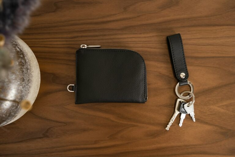 Black leather wallet and keys on a wooden table